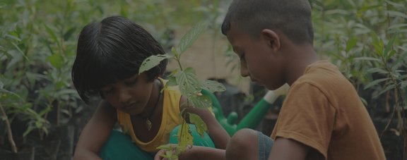 Two children planting a tree